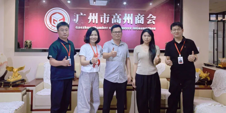 五位嘉宾在广州市高州商会室内合影竖起大拇指,背景展示小红书门店获客相关商会标识